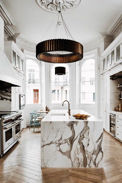 a luxurious white kitchen with a large kitchen island and a fantastic white marble countertop that wows at once