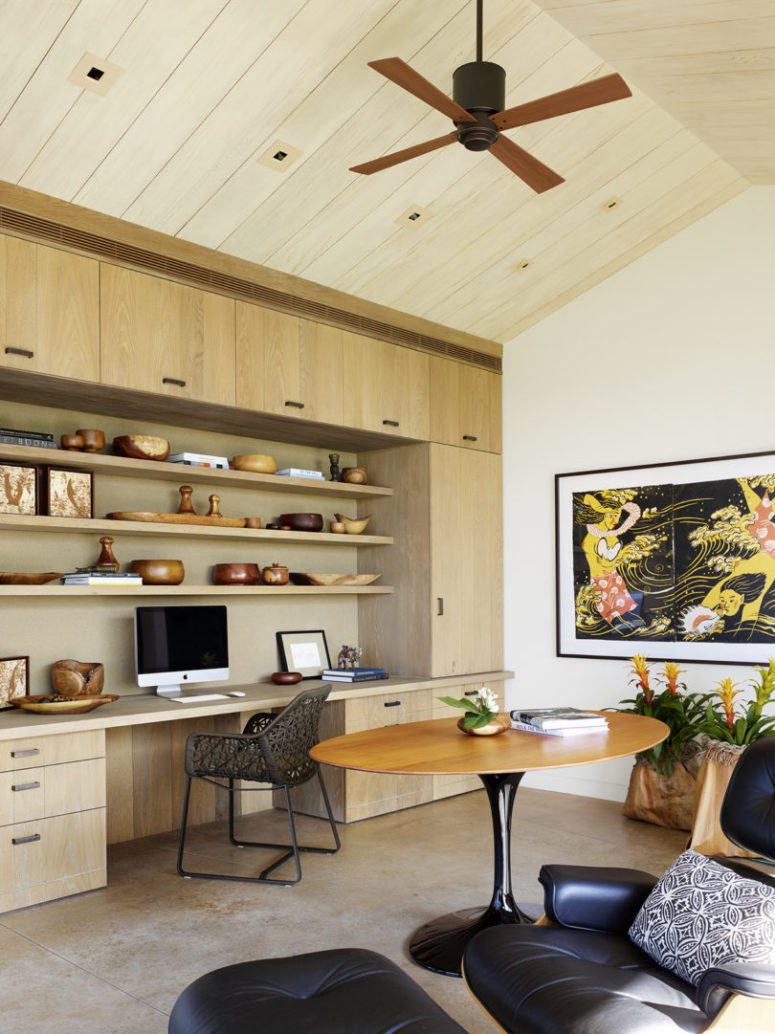 The home office features a built-in desk and shelves and cool wooden art and accessories
