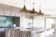 18 a neutral wooden kitchen with a large kitchen island topped with a gorgeous stone waterflal countertop that brings a luxurious feel