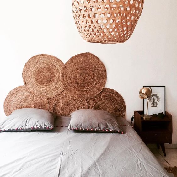 a stack of jute rugs, a wicker lamp make the bedroom feel more natural and more outdoor-inspired