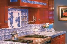 23 a rich-stained kitchen of wood accented with blue tile countertops and a matching backsplash to make it bold