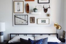 24 a white pegboard with artworks and potted greenery over the bed is a creative and cool alternative to a usual headboard
