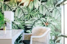 a bold tropical home office with an accent wall, leather chairs, touches of gold and brass and greenery