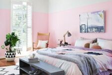 a bright bedroom with light pink color block walls, colorful bedding and a color block pillow