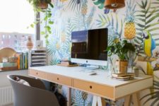 a bright tropical home office with a super bold accent wall, a cork lamp, some plants, a trestle desk and a grey chair