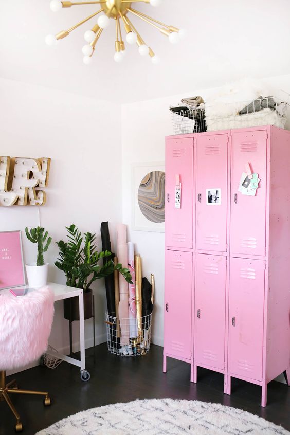 a catchy home office with a pink storage unit, a pink artwork and a fluffy chair plus gold touches looks super glam