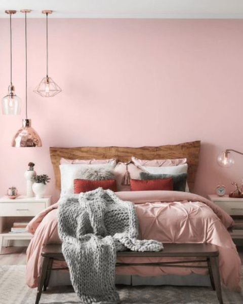a chic contemporary bedroom with a pink statement wall, pink bedding, grey touches, pendant lamps and white furniture