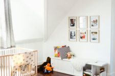 a colorful attic nursery with a pink ceiling, a gallery wall, bright printed textiles and a wicker pendant lamp