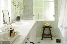 a cozy small bathroom with a large vanity and a built-in sink, a dark stained floor, a light green shower space