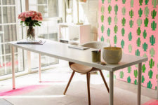 a creative home office with a pink cactus statement artwork, a pink stripe rug and blooms plus neutral furniture