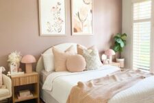a lovely bedroom with a mauve accent wall, a white upholstered bed and neutral bedding, a mini gallery wlal, fluted nightstands