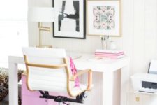 a modern home office with touches of pink – in the gallery wall, books, a pillow and a storage unit under the desk