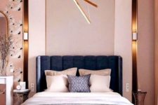 a modern luxurious bedroom with pink walls, catchy wallpaper, a navy bed, neutral bedding and touches of gold here and there