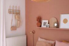 a pink boho bedroom with a ledge gallery wall, a bed with pink bedding, a woven pendant lamp and blush curtains
