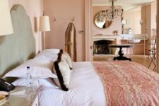 a refined blush bedroom with a grey bed and pink and white bedding, mirror nightstands, table lamps and a fluffy rug