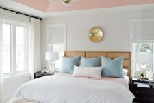 a refined mid-century modern bedroom with a pink ceiling, pink and blush ottomans for softening the color scheme