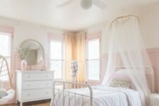 a romantic and airy girlish bedroom with pink panaled walls, a pink vase and window frames