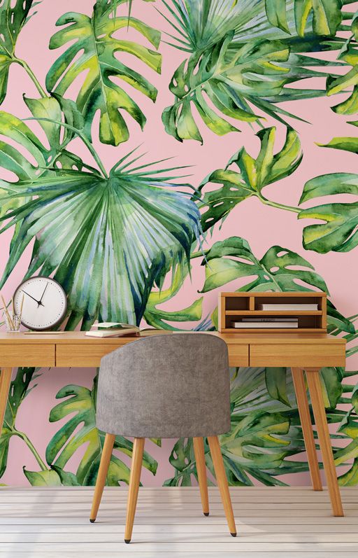 a simple tropical home office with an accent wall, a wooden desk, a grey chair and a clock is very chic