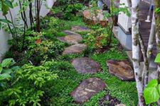 a small Japanese-inspired garden with rocks as pavements, greenery, shrubs and a couple of trees is very peaceful