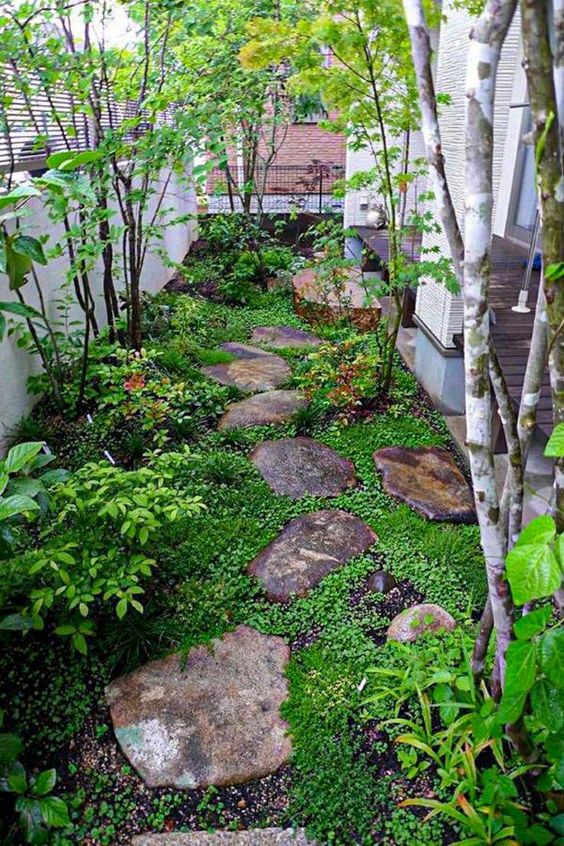 A small Japanese inspired garden with rocks as pavements, greenery, shrubs and a couple of trees is very peaceful