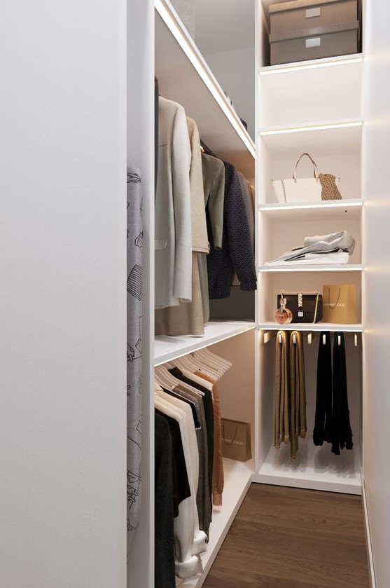 A small and narrow minimalist closet with open storage units, lit up shelves and some boxes on top doesn't look cluttered and is well organized