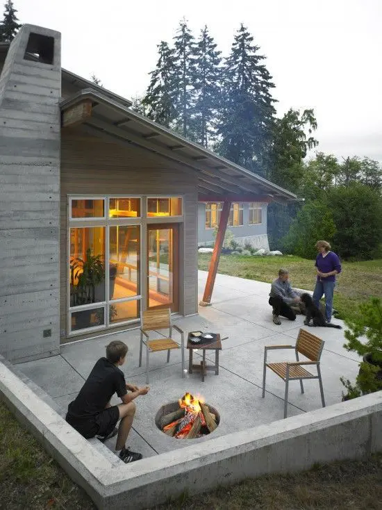 A small and ultra modern patio with a fire pit, some chairs and a table and nothing else is very laconic