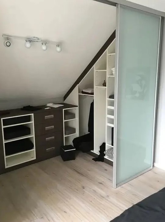 A small attic spot turned into a walk in closet, with built in shelves, dressers and glass sliding doors is a cool idea