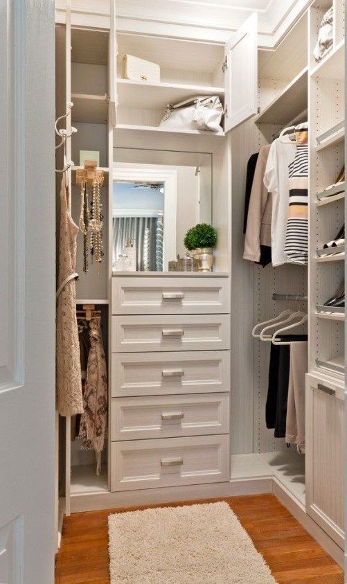A small chic closet with built in drawers, open storage compartments and shelves and built in lights is a lovely space