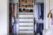 a small closet with rails and hangers, drawers and open shelves with baskets is a smart and cool solution for a bedroom