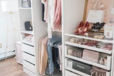 a small glam closet with holders and hangers, built-in drawers, open shelving, artworks, a faux fur stool and a printed rug