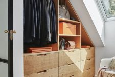 a small modern attic closet with open storage compartments and drawers and a chair is a comfortable and cool solution