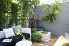 a small modern patio with a storage bench, a metal chair and table and lush greenery here to refresh the space