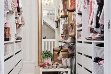 a small vintage-inspired sweet closet with a large mirror, a crystal chandelier, open shelves and holders plus drawers