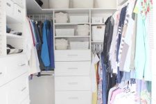 a small white closet with open shelves and baskets and boxes, built-in drawers and rails for clothes is a cool idea