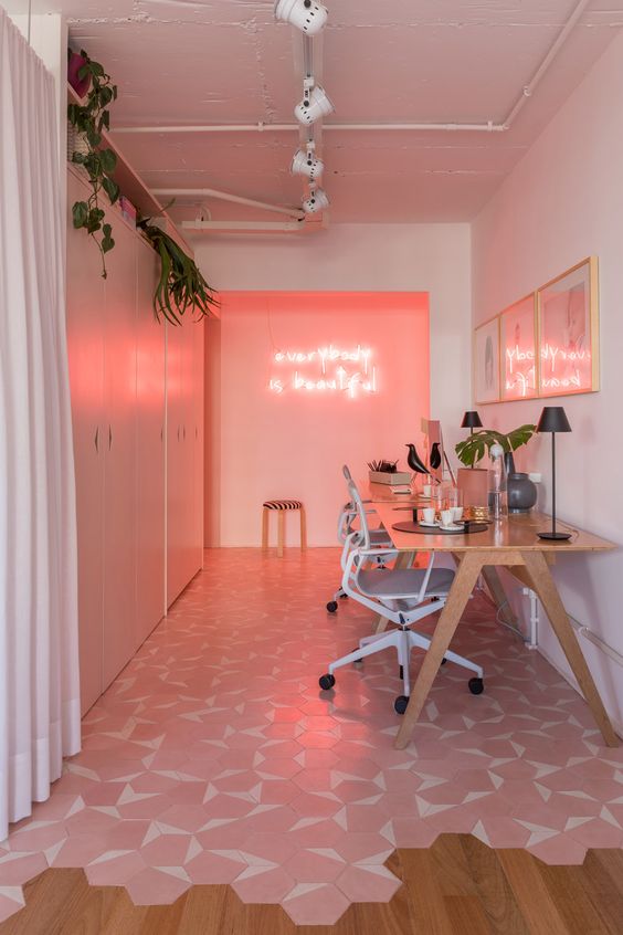 a super modern home office with a pink wall and neon lights, a pink gallery wall, a pink and white tile floor and sleek storage units