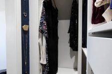 a tiny minimal closet with open shelves, open storage compartments and some drawers plus wall organizers for jewelry