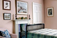 a vintage-inspired farmhouse bedroom with wooden beams, blush walls, a fireplace, green and pink printed textiles here and there