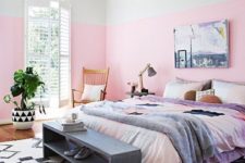 a whimsy modern bedroom with bright color block walls, a wicker lamp, colorful bedding, wooden furniture and a statement plant