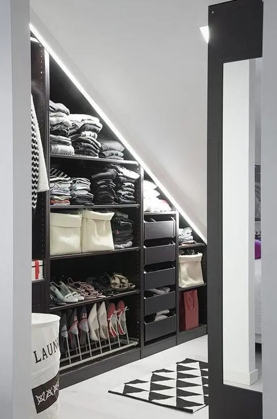 An attic nook as a closet, with open shelves, drawers and built in lights, a printed rug is a cool and smart idea if you lack space