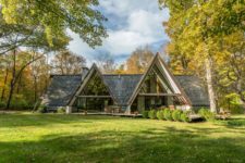 01 This beautiful mid-century modern home features severla A-frame sections and is surrounded with woods