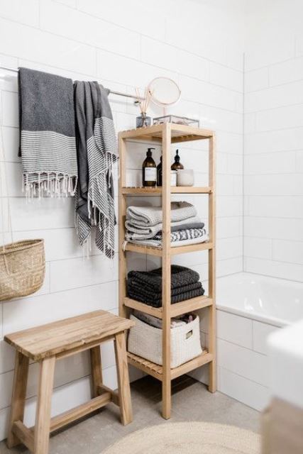 a minimalist wooden shelf with towels and various necessary bathroom stuff and railing for towels over it