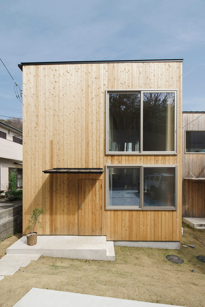 The house is clad with light-colored wood on the outside and several windows bring much light in