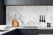 03 a black minimalist kitchen with sleek cabinets, neutral stoen countertops and a white marble backsplash