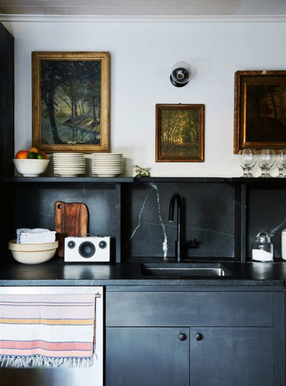 A black vintage inspired kitchen with a black marble backsplash and countertops for a refined touch