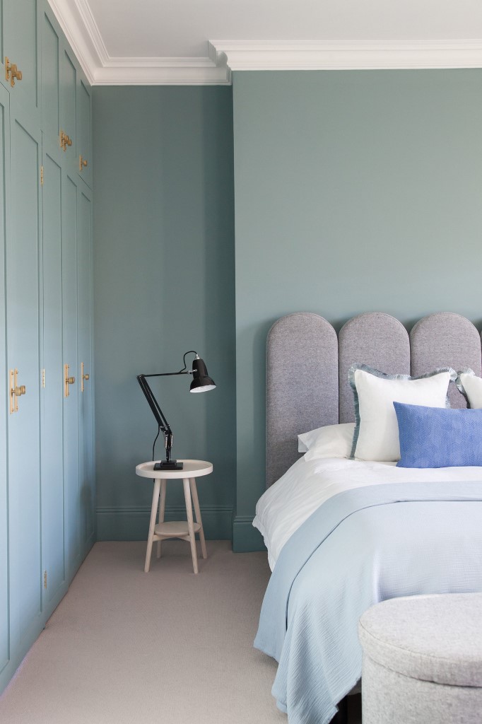 The master bedroom shows off powder blue walls and again catchy upholstered furniture
