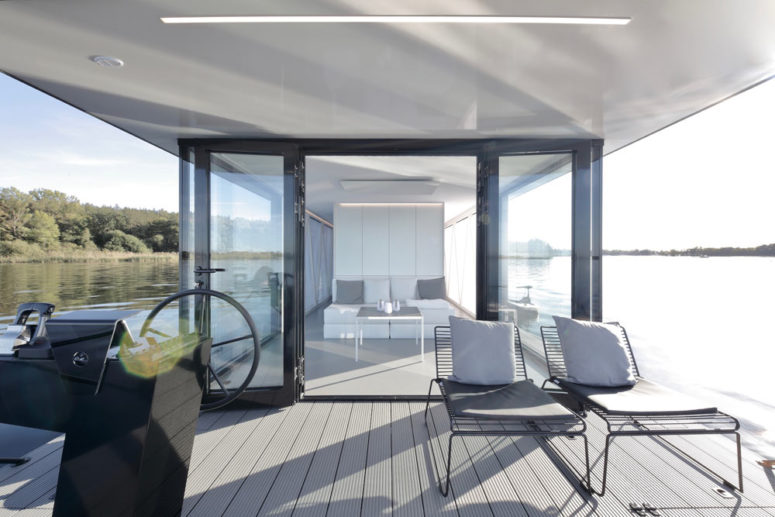 The lower terrace or deck features a couple of loungers and glass doors to inside