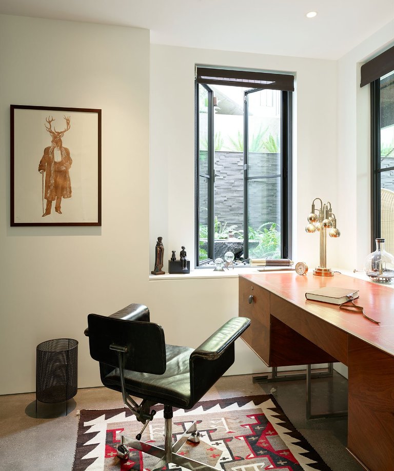 The home office is done with stylish mid-century modern furniture and much natural light