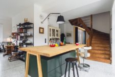 07 There’s a large quirky kitchen island with sleek green drawers and a wooden countertop