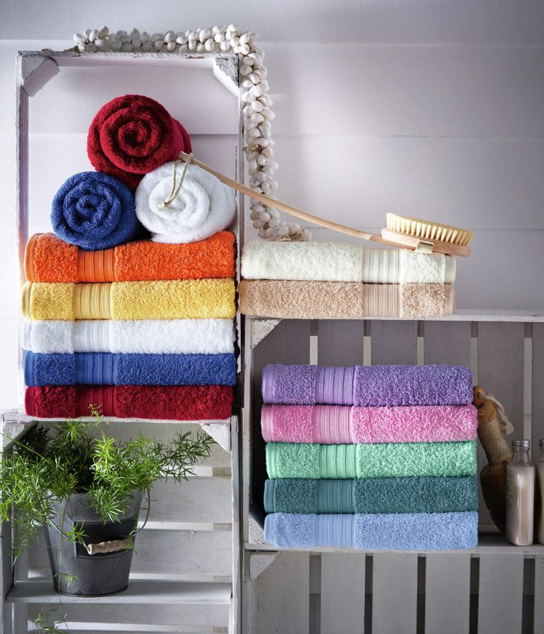 crates repurposed into wall shelves to store towels, a plant and other bathroom stuff you may need