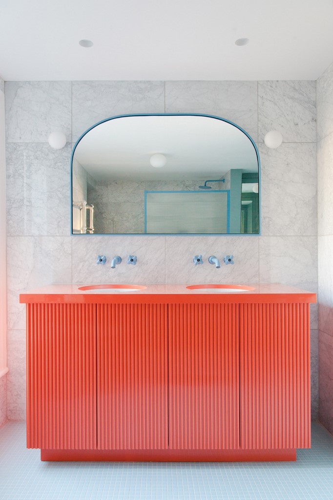There's a red vanity and touches of blue   frames, fixtures and other details